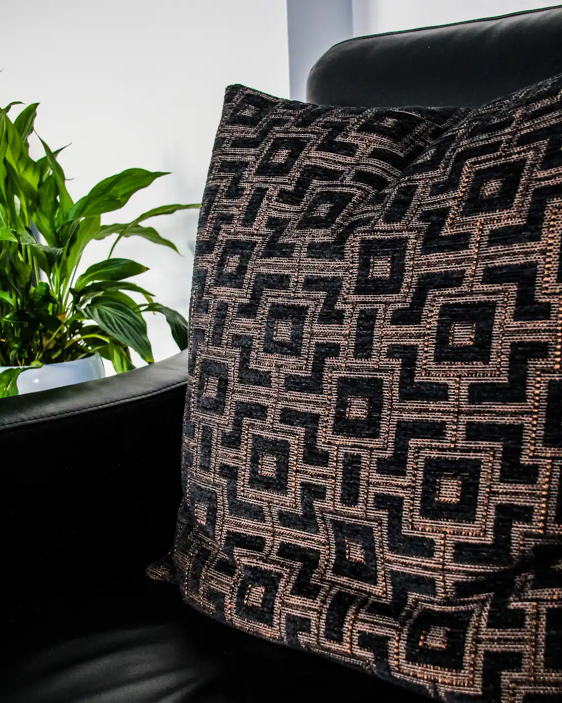 PLACEHOLDER: a monochrome cushion on a sofa, standing in for a Monolit cover in a living room.
