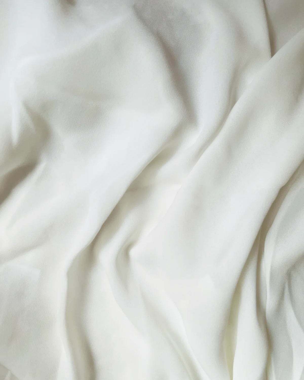 PLACEHOLDER: white satin standing in for the Monolit Panther pillow cover, the motif machine-embroidered and held by tensioned thread, shot against brushed metal.